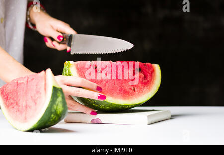 Frau, schneiden Wassermelone auf ein Schneidebrett Stockfoto