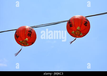 Zwei roten Lampions hängen vor einem blauen Himmel wehen sanft im Wind, Taipei, Taiwan. Stockfoto