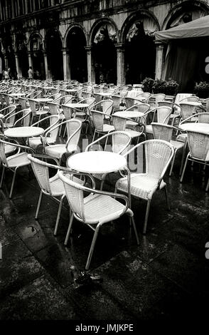 Restaurant Stühle und Tische stehen auf dem Platz Sant Marco in Venedig, Italien. Datum: 03/2010. Photoghrapher: Xabier Mikel Laburu Van Woudenberg. (* Aufnahme in s/w Film EI: 800 ISO und auf einem Epson V700 gescannt) Stockfoto