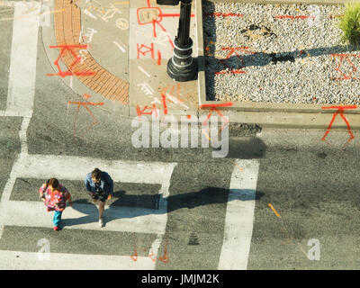 Menschen in städtischen Kreuzung wo Bau Markierungen sehen aus wie Runen gefangen von Oben Stockfoto