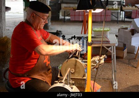 Mann bei einem Markt in der französischen Stadt Monpazier Messer schärfen Stockfoto