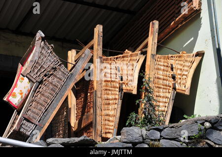 Holz/Wicker Schlitten verwendet, in der Tourismusbranche in Madeira um Menschen bergab auf den Fahrbahnen, gesteuert durch zwei Operatoren Stockfoto