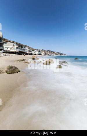 Häuser direkt am Meer mit Motion blur Wasser bei Carbon Beach in Malibu, Kalifornien. Stockfoto