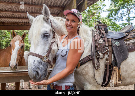 Frau und Pferde im Na'alapa Stall im Waipio Valley auf der Big Island von Hawaii Stockfoto