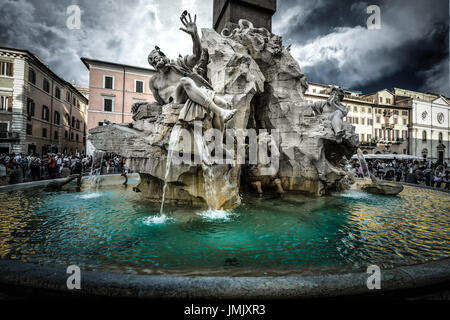 Der Brunnen der vier Flüsse von Bernini auf der Piazza Navona in Rom. Der Himmel ist dunkel mit einem Sturm kommen. Stockfoto