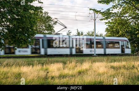 Eine Lothian Straßenbahn beschleunigt durch die in der Nähe von Stenhouse, westlich der Innenstadt in Edinburgh, Schottland, Großbritannien Stockfoto