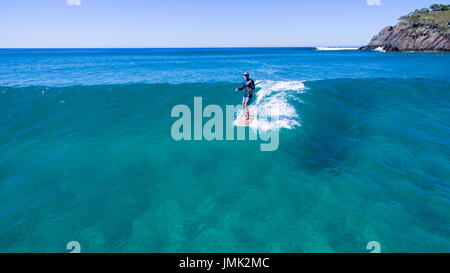 Surfer, Surfen auf dem kristallklaren Wasser. Stockfoto