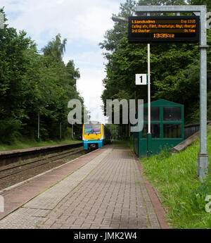 Arriva Züge Wales ATW Klasse 175 Personenzug kommt bei Runcorn Osten auf einem Manchester Flughafen an Llandudno-Dienst unter einem Hinweisschild. Stockfoto