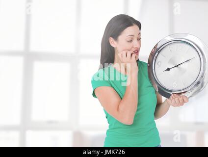 Digitalen Verbund von Frau Holding Uhr vor Fenstern Stockfoto