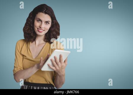 Digital Composite Happy Business-Frau mit einem Tablet vor blauem Hintergrund Stockfoto