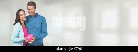 Digitalen Verbund von glücklichen Paar hält ein Sparschwein vor weißem Hintergrund mit Fackeln Stockfoto