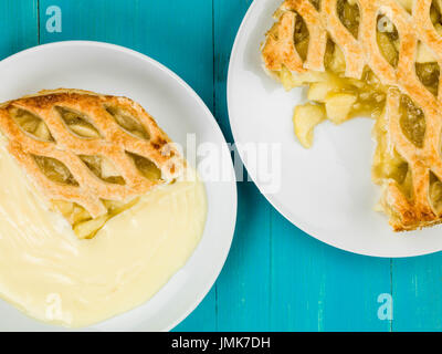 Apfelkuchen und Pudding Dessert auf blauem Grund aus Holz Stockfoto