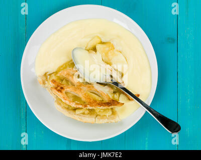 Apfelkuchen und Pudding Dessert auf blauem Grund aus Holz Stockfoto