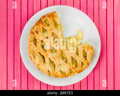 Gebackene Apfelkuchen und Pudding Dessert gegen eine Rosa Holz- Hintergrund Stockfoto