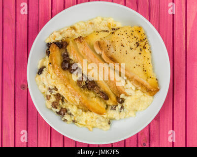 Traditionelle Bread And Butter Pudding gebacken Dessert vor einem rosa Hintergrund aus Holz Stockfoto