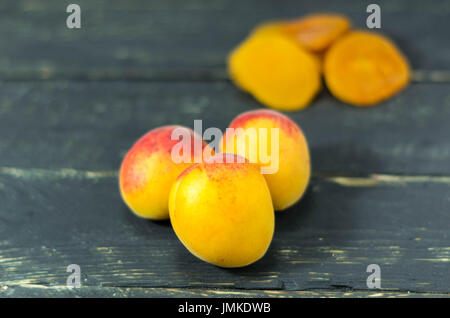 Frische Aprikosen und getrockneten Aprikosen. Dunklem Holz. Gesund. Stockfoto