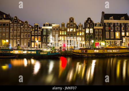 Blick auf die Amsterdamer Grachten und Böschungen entlang sie nachts. Stockfoto