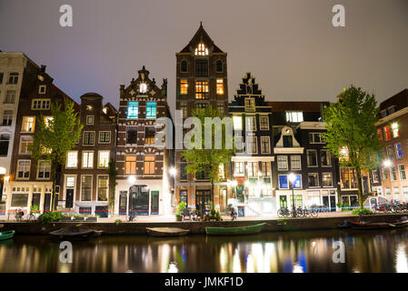 Blick auf die Amsterdamer Grachten und Böschungen entlang sie nachts. Stockfoto