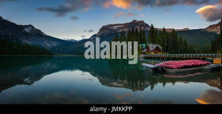 Kanus am wunderschönen Emerald See Lake Lodge und Restaurant im Hintergrund bei Sonnenuntergang, Yoho Nationalpark, Britisch-Kolumbien, Kanada. Lange exposu Stockfoto