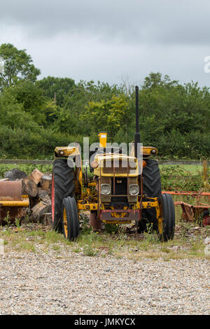 Alte gelbe Traktor auf Brachland. Stockfoto