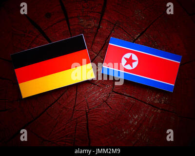 Deutsche Flagge mit nordkoreanischer Flagge auf einem Baumstumpf, isoliert Stockfoto
