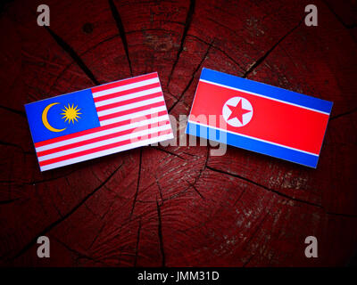 Malaysische Flagge mit nordkoreanischer Flagge auf einem Baumstumpf, isoliert Stockfoto