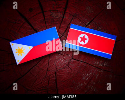 Philippinen-Flagge mit nordkoreanischer Flagge auf einem Baumstumpf, isoliert Stockfoto