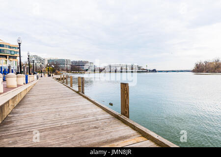 Washington DC, USA - 20. März 2017: Georgetown Hafen tagsüber am Flussufer mit Promenade, Gebäuden und Brücke Stockfoto