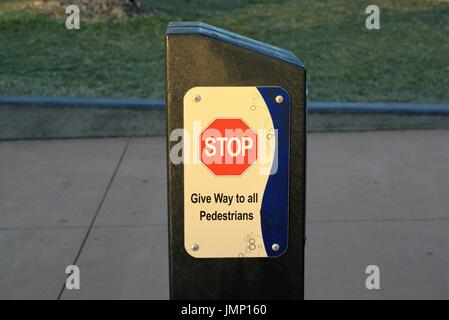 Rote Stoppschild auf Säule. Wegweiser an einem öffentlichen Ort sagt "Stop Vorfahrt für alle Fußgänger" Stockfoto