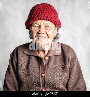 Portrait einer älteren Frau lächelnd mit Vintage Kostüm. Auf grauem Hintergrund isoliert Stockfoto