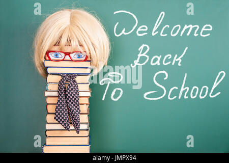 Frau Lehrerin vor Tafel mit Titel WELCOME BACK TO SCHOOL Stockfoto