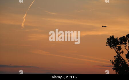 Flugzeug fliegen über den Himmel bei Sonnenuntergang in Venedig, Italien Stockfoto