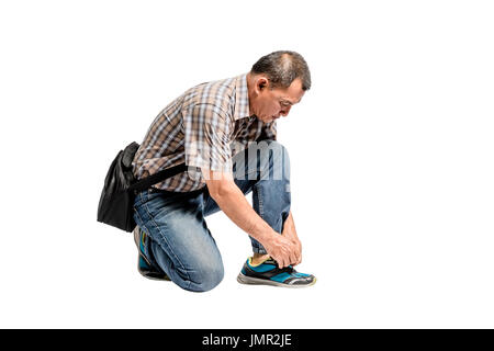 Porträt eines glücklichen Reifen Scott Hemd und blaue Jeans seine Schuhe zu binden. Isolierte voller Länge auf weißem Hintergrund mit textfreiraum und Clipping-pa Stockfoto