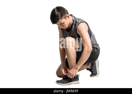 Porträt eines asiatischen Sportart Mann seine Schuhe für den Betrieb zu binden. Isolierte voller Länge auf weißem Hintergrund mit textfreiraum und Clipping-Pfad Stockfoto