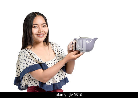 Porträt einer schönen asiatischen Frau lächelnd und Teekanne in den Händen halten. Isoliert auf weißem Hintergrund mit textfreiraum und Clipping-Pfad Stockfoto