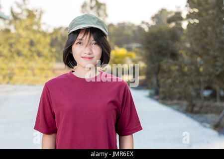 Porträt einer jungen asiatischen Frau im roten T-shirt mit Kappe Stockfoto