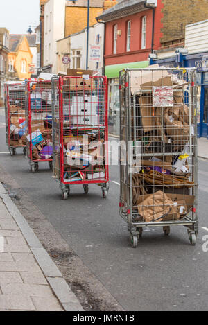 Kartonverpackungen aus Supermärkten stapeln sich im Käfig Wagen auf der Straße in Whitstable warten über Abfallentsorgung Fahrzeuge erfasst werden. Stockfoto