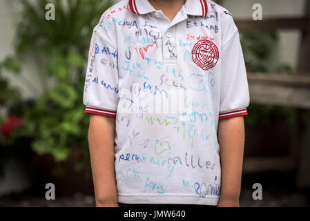 Jungen Junior Schüler trägt ein weißes Hemd von all seinen Freunden am Ende der Schule unterzeichnet im Sommersemester. Newquay, Cornwall. Stockfoto