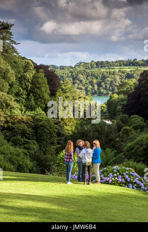 Menschen entspannen sie auf dem Rasen im subtropischen Trebah Garten in Cornwall Stand. Stockfoto