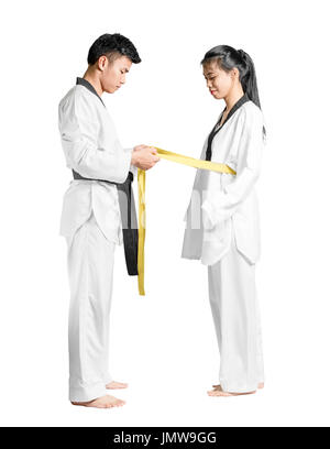 Porträt von einem asiatischen Mann professionelle Taekwondo Schwarzgurt Grad (Dan) gibt gelben Gürtel Grad Frau. Isolierte voller Länge auf weißem Hintergrund wi Stockfoto