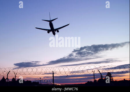 Skyline von Passagiere Flugzeug Landung bei Sonnenuntergang Stockfoto