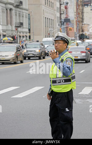 Eine asiatische männlichen Verkehrspolizist regelt den Verkehr auf Cana Street in Chinatown, Manhattan, New York City. Stockfoto