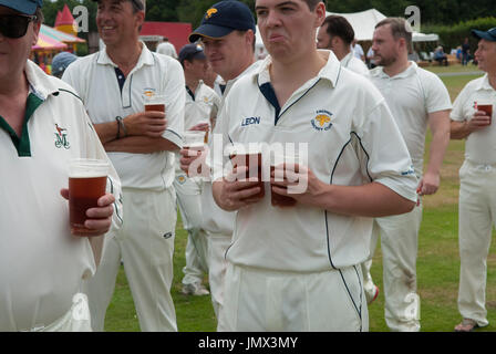 Englisches Village Life Cricket Team mit Bier während der Mittagspause im Spiel. Der Ebernoe Cricketclub spielt jährlich ein Horn Fair Cricketspiel auf dem Common. Ebernoe CC gegen Wessex Pilgrims Cricket Club. Ebernoe, Sussex, England. 2010ER 2015 UK HOMER SYKES Stockfoto