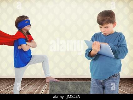 Digital Composite jungen auf Tablet und Superhelden Mädchen im Zimmer Stockfoto