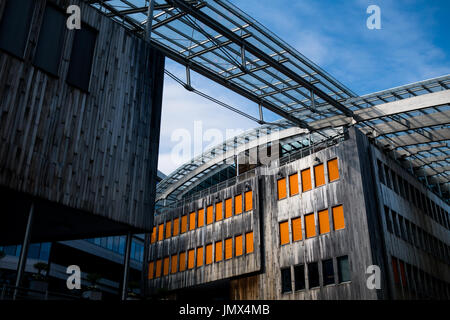 Moderne Gebäude in rustikale Holzplatte mit orange Fensterabdeckungen gekleidet und umgeben von Stahl-und Glas Stockfoto