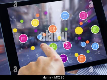 Digital Composite Tablet und Stadt mit bunten Icons zu halten Stockfoto