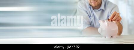 Digitalen Verbund der Mann, der Münzen in ein Sparschwein Stockfoto