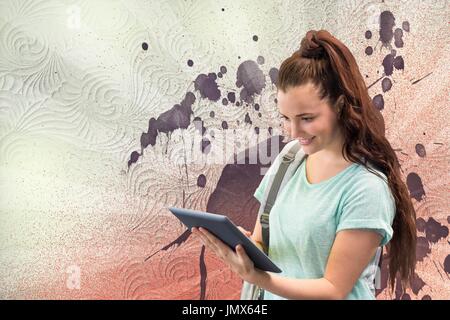 Digital Composite glückliche junge Studentin Frau mit einer Tablette gegen weiße, rote und violette bespritzt Hintergrund Stockfoto