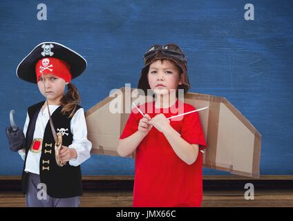 Digital Composite Pirate Girl und Pilot jungen vor blauer Wand Stockfoto