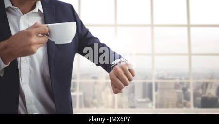 Digitalen Verbund aus Business-Mann hält eine Tasse Kaffee gegen den Bau Hintergrund Stockfoto